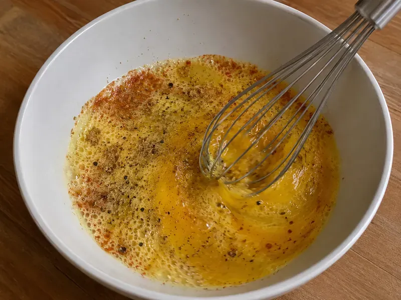 Eggs and egg whites whisked with salt, black pepper, chili powder, and cumin.