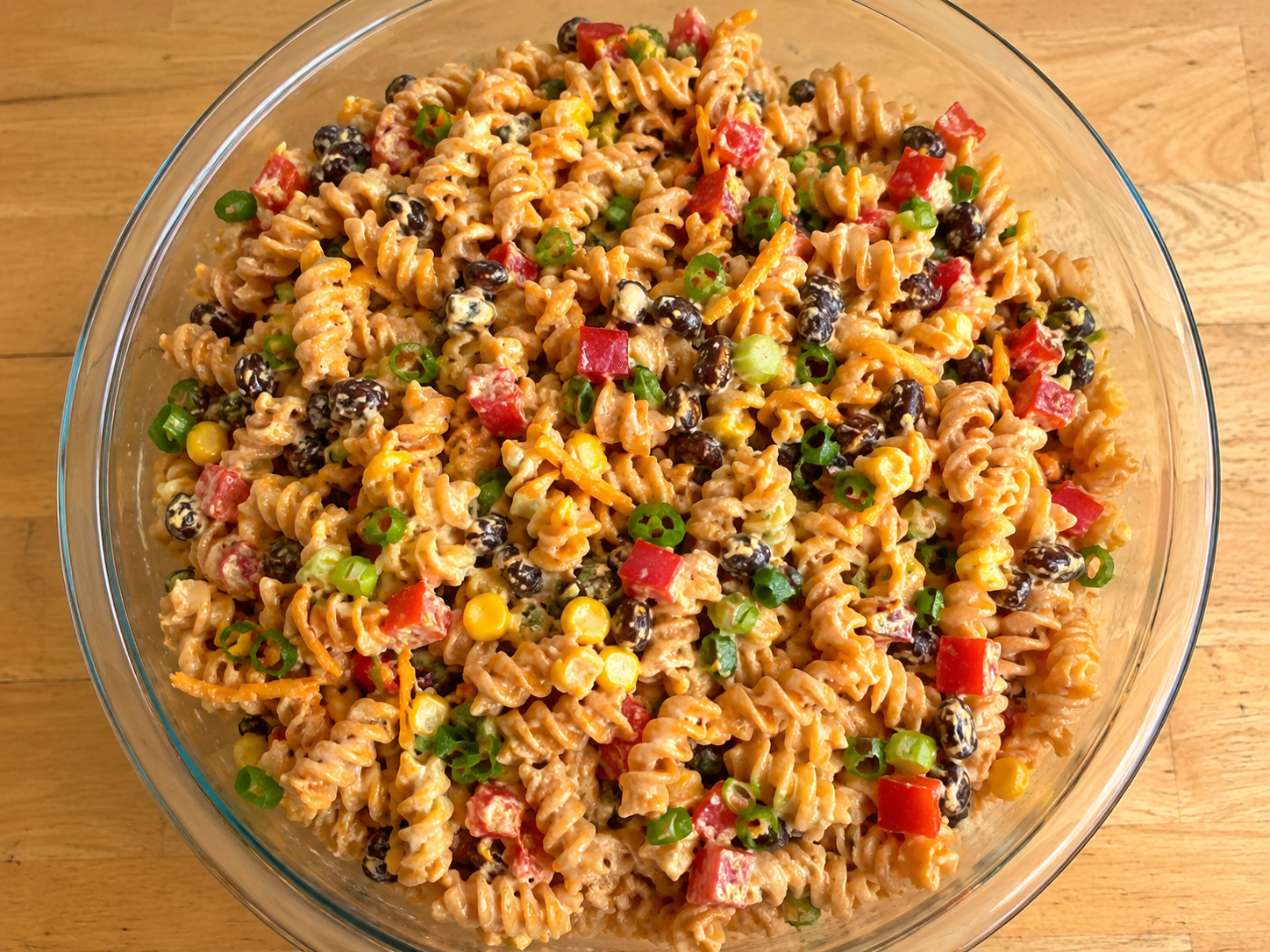 BBQ ranch pasta salad with pasta, corn, black beans, red bell pepper, cheddar cheese, green onions, and creamy dressing.