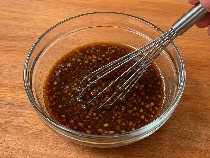 Soy sauce, beef broth, brown sugar, garlic, ginger, sesame oil, and cornstarch mixed in a bowl for beef and broccoli sauce.