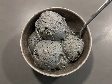Black Sesame Ice Cream final image showing creamy gray-black sesame ice cream scoops with a smooth texture, toasted black sesame specks, and a simple realistic dessert setup.