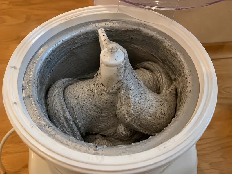 Black sesame ice cream churning with a creamy gray texture.