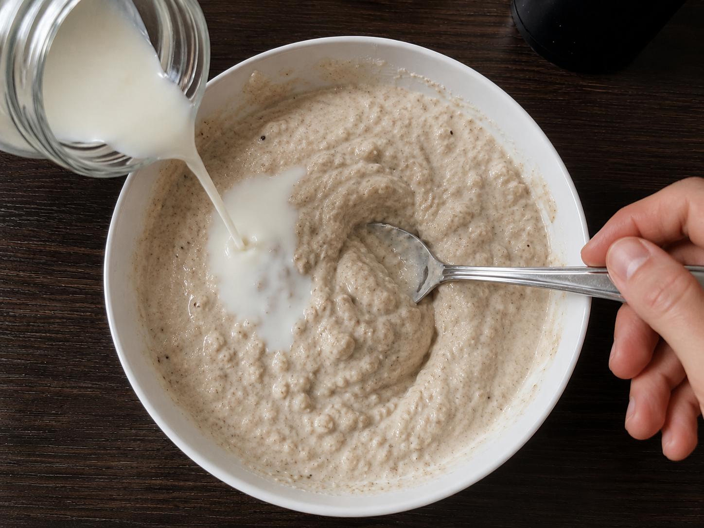 Milk stirred into Greek yogurt protein bowl mixture to adjust the texture.