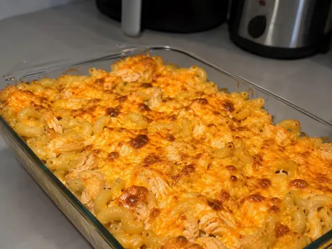 Buffalo Chicken Mac and Cheese Bake in a baking dish with creamy pasta, buffalo chicken, melted cheese, and a golden top.