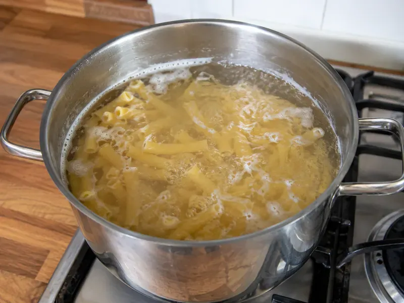 Ziti pasta cooking in a pot of salted boiling water before making baked ziti.