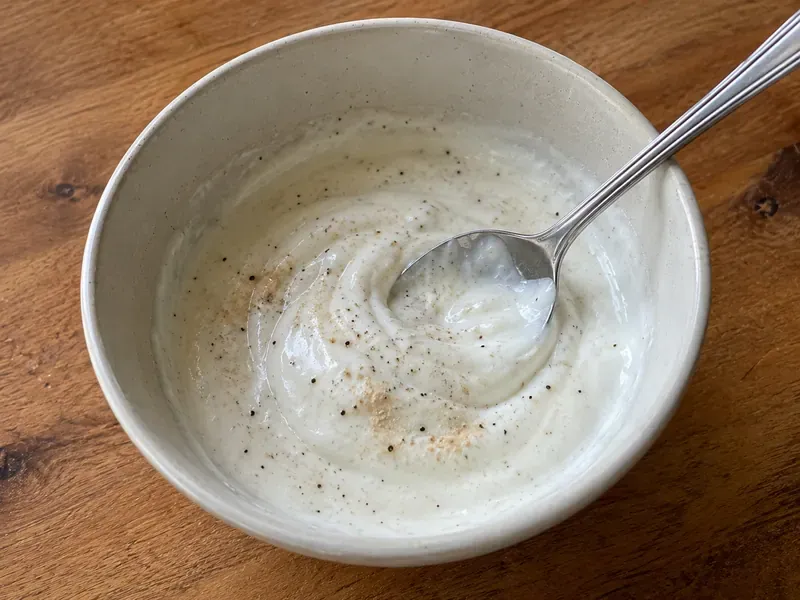 Lime yogurt sauce mixed in a bowl with Greek yogurt, lime juice, garlic powder, salt, and pepper.