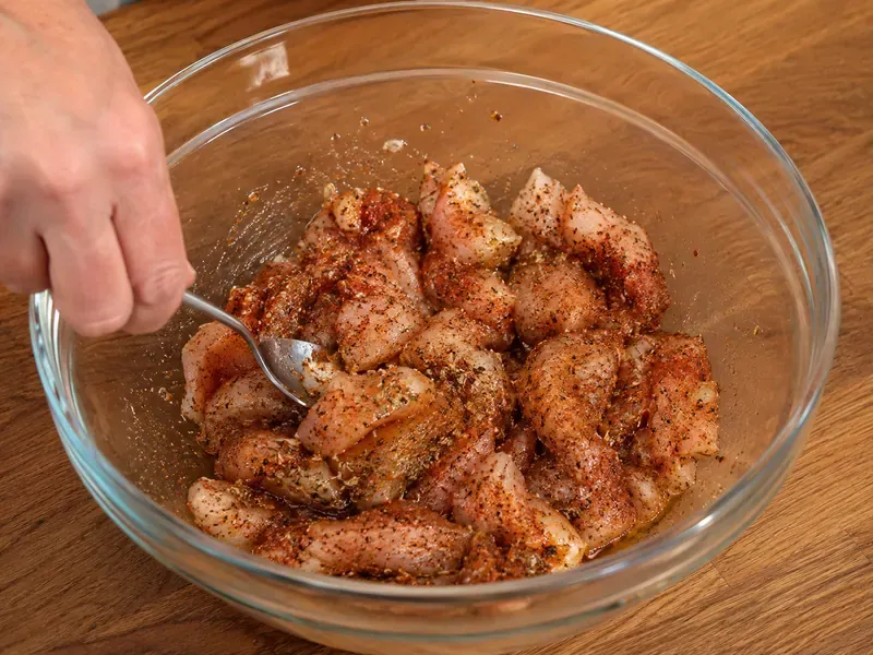 Chicken tossed with fajita seasoning in a bowl.