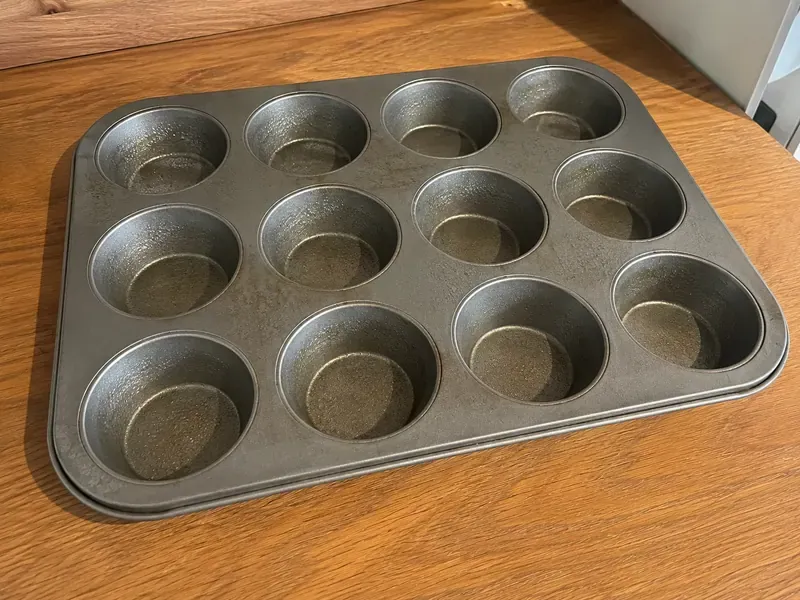 A greased muffin tin ready to be filled for cottage cheese egg bites.