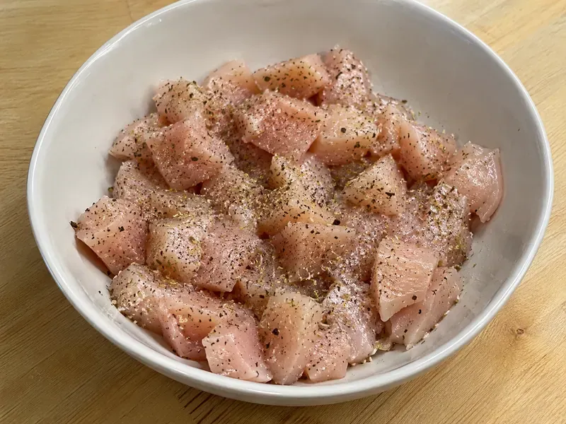 Chicken pieces seasoned with Italian seasoning, salt, and black pepper before cooking.