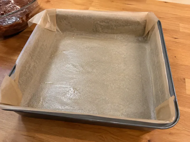 Parchment-lined baking pan prepared for Dr Pepper brownies.