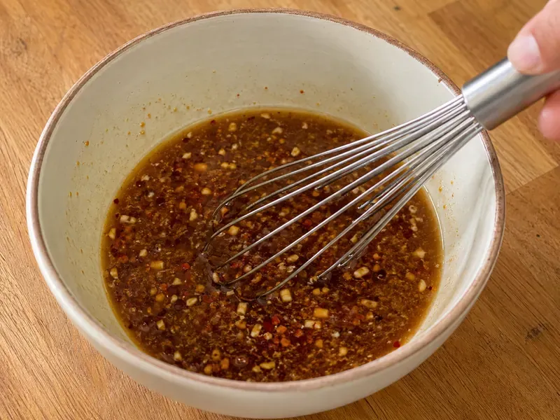Sauce mixed with broth, soy sauce, rice vinegar, sesame oil, garlic, ginger, and chili crisp.