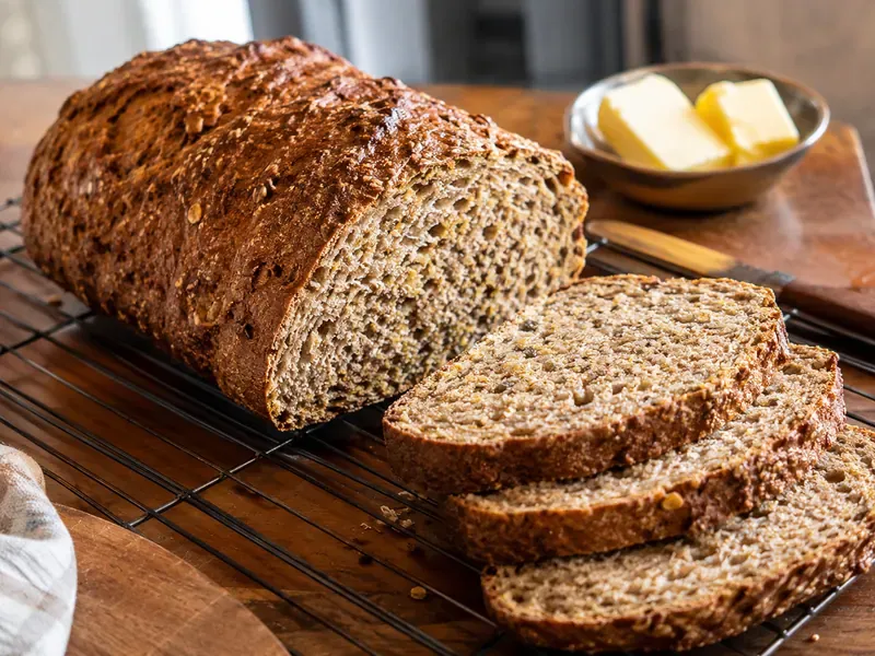 Finished Ezekiel bread loaf sliced to show a hearty whole-grain crumb.