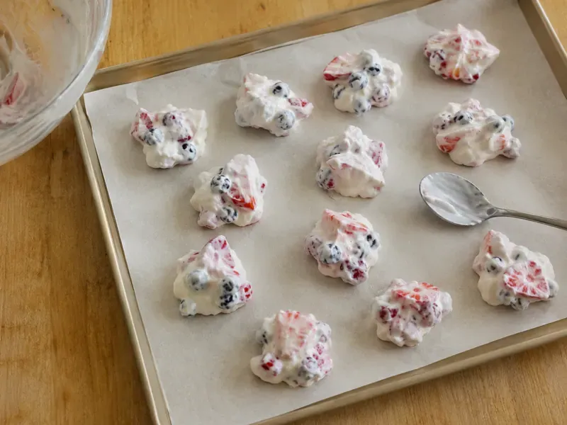 Small yogurt fruit clusters spooned onto parchment paper.