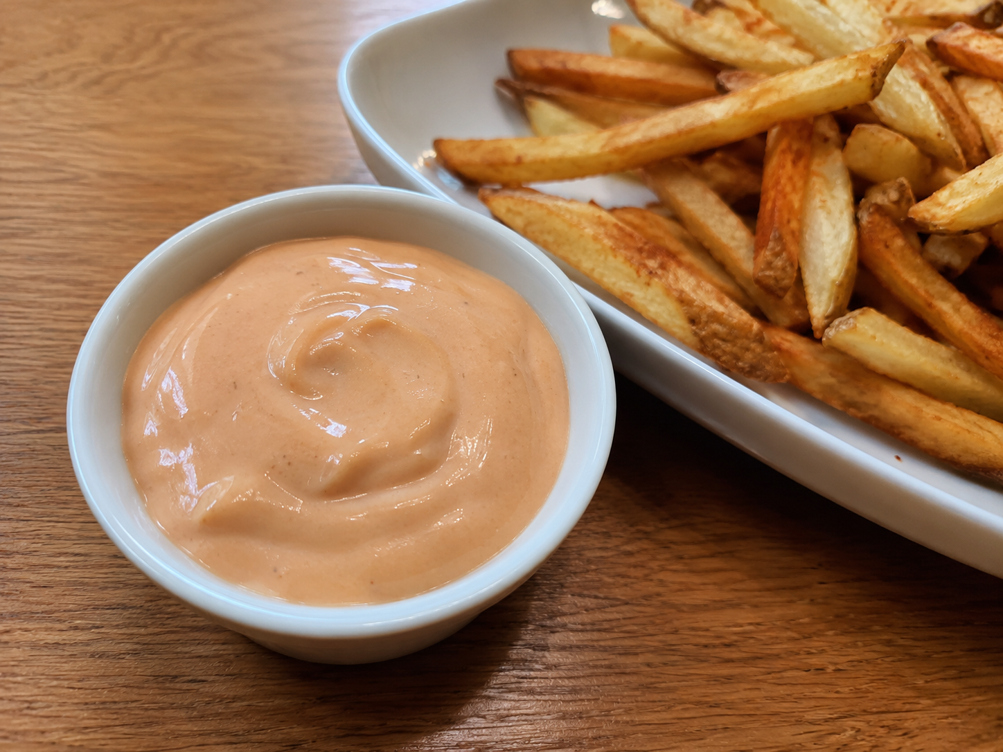Fry sauce served in a ramekin with golden fries for dipping.