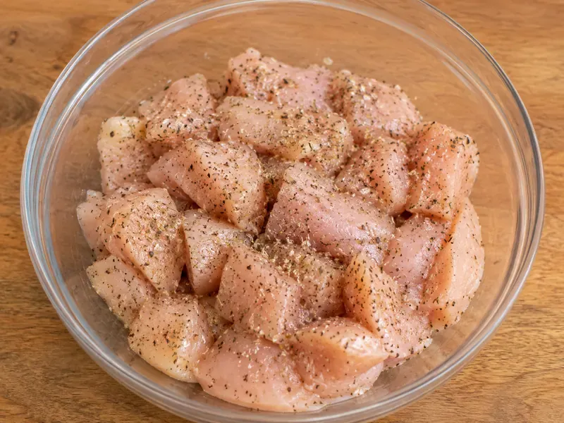 Chicken pieces seasoned with Italian seasoning, salt, and black pepper before cooking.