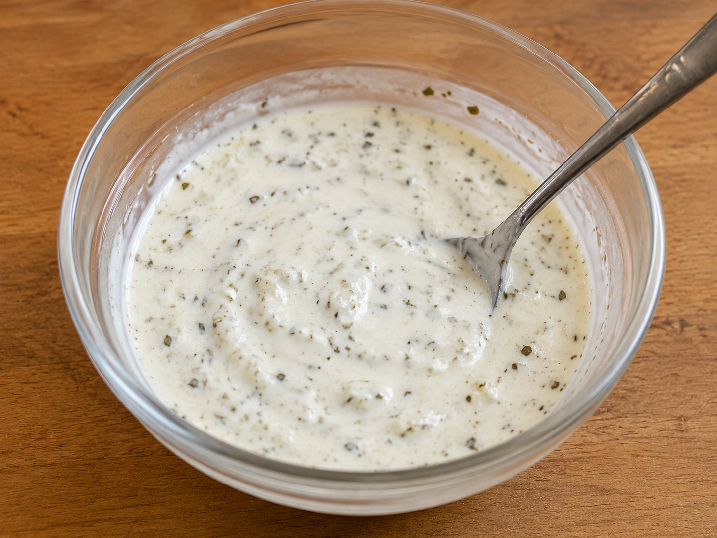 Lemon yogurt dressing mixed with garlic, oregano, salt, and pepper for Greek chicken salad boxes.