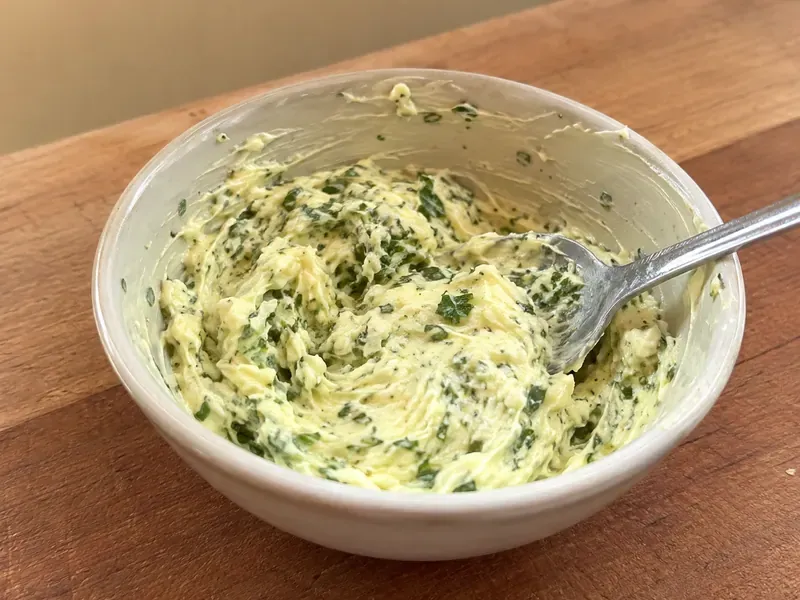 Garlic herb butter mixed in a small bowl with parsley and garlic.