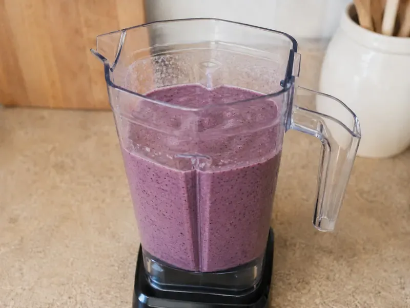 Greek yogurt and milk poured into the blender with berries and oats.