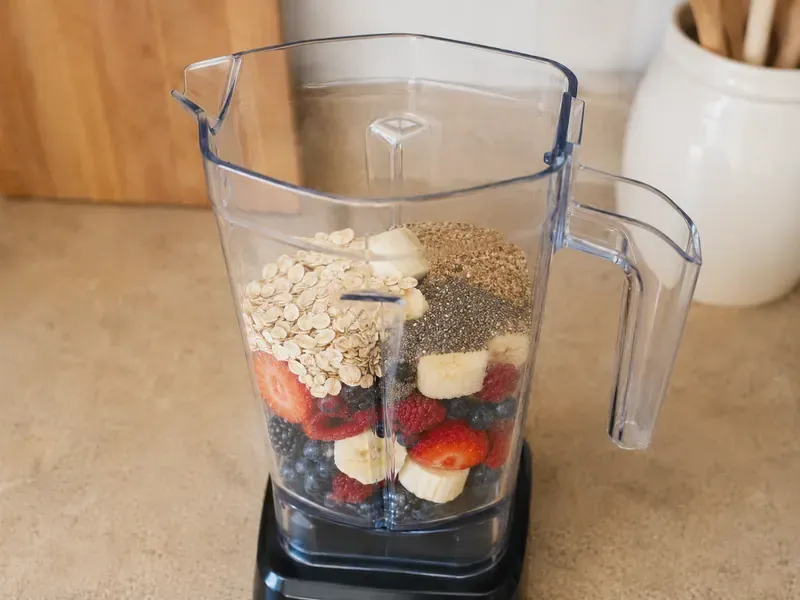 Thick purple berry smoothie blending until creamy and smooth.
