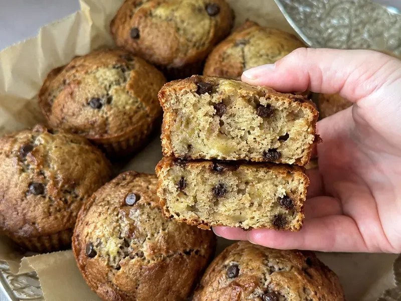 High protein banana muffins with Greek yogurt, golden tops, banana texture, and optional chocolate chips or walnuts.