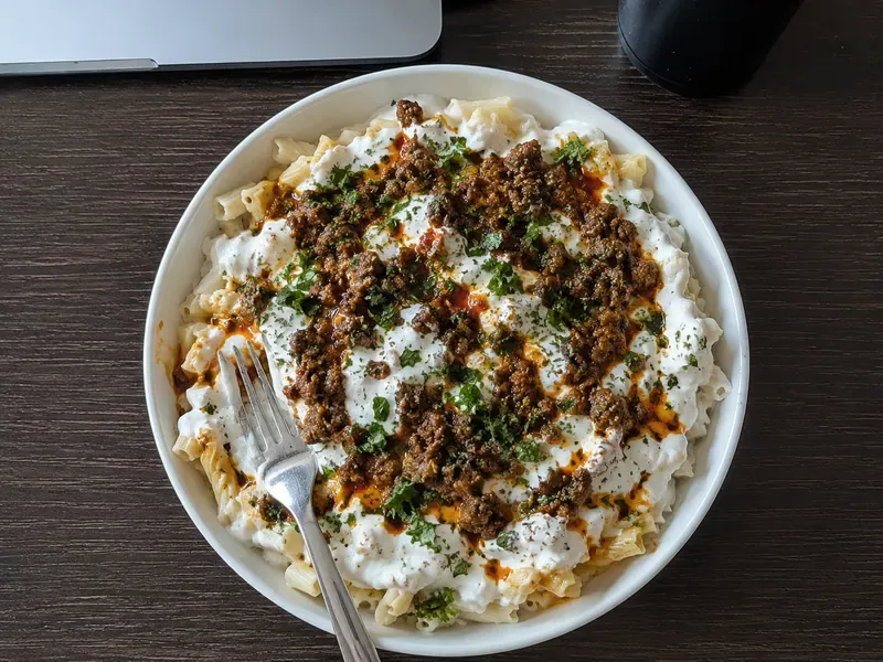 High protein Turkish pasta with seasoned ground beef, garlic yogurt sauce, chili butter, parsley, and herbs.