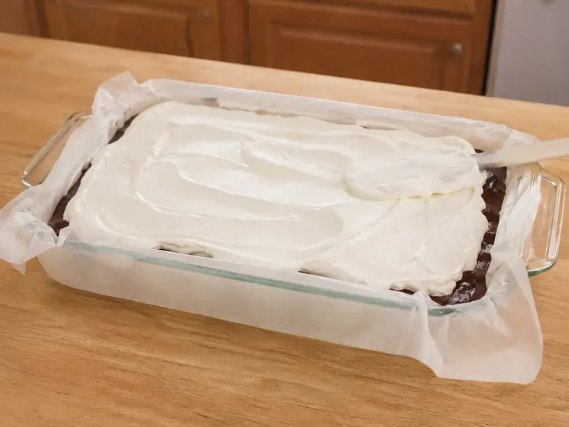 Whipped topping spread over the fudge layer with a spatula.
