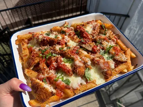 Loaded Chicken Parmesan Fries with crispy fries, breaded chicken, marinara sauce, melted mozzarella, parmesan, and herbs.