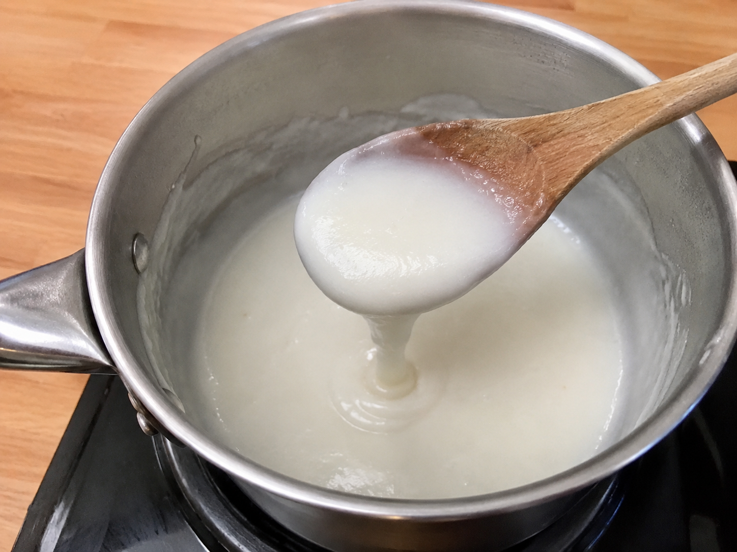 Coconut sauce stirred in a saucepan until lightly thickened.