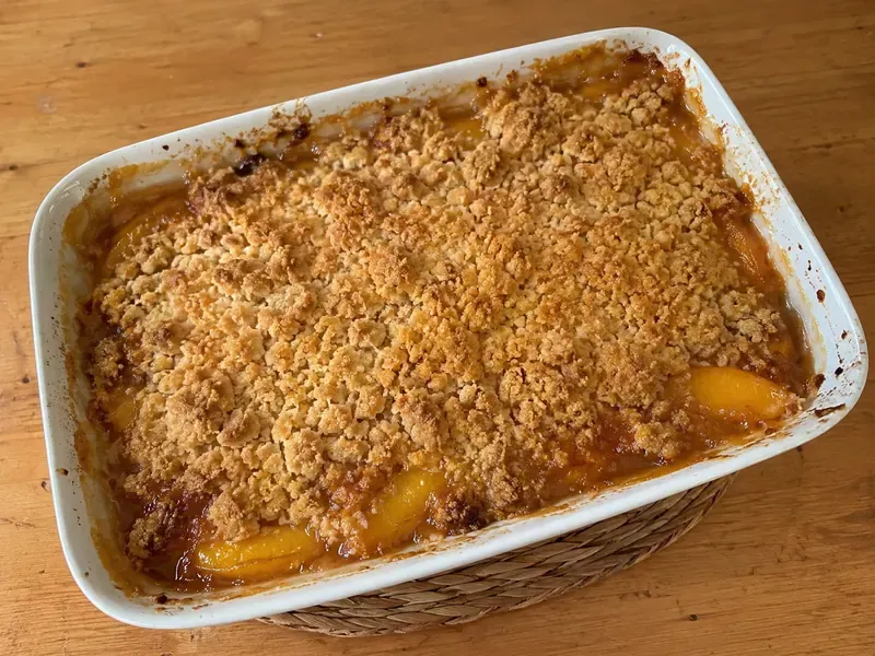 Peach crumble baked until golden with bubbling fruit edges.