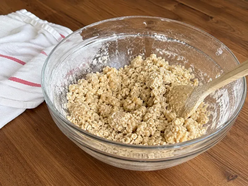 Crumbly oat and flour mixture for raspberry crumble bars in a mixing bowl.