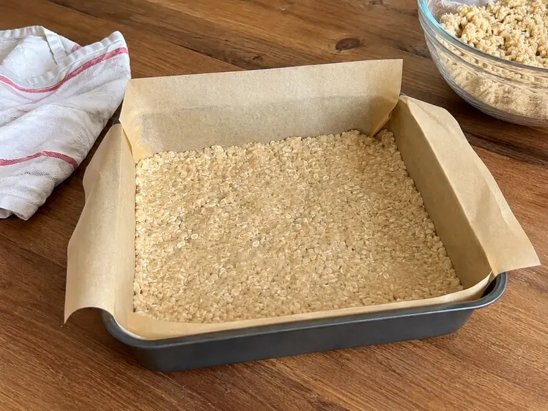 Buttery crumble mixture pressed into a baking pan to form the crust.