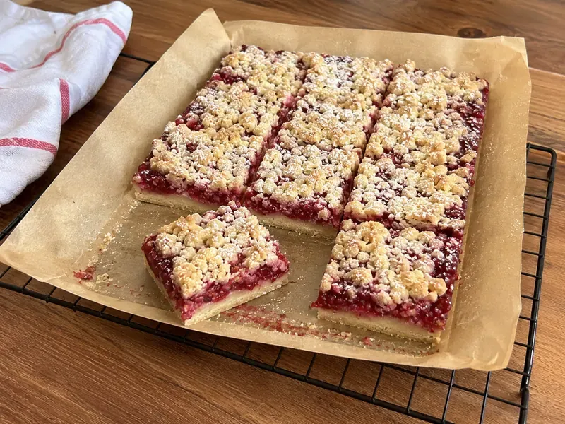 Finished raspberry crumble bars sliced into fruity buttery squares.