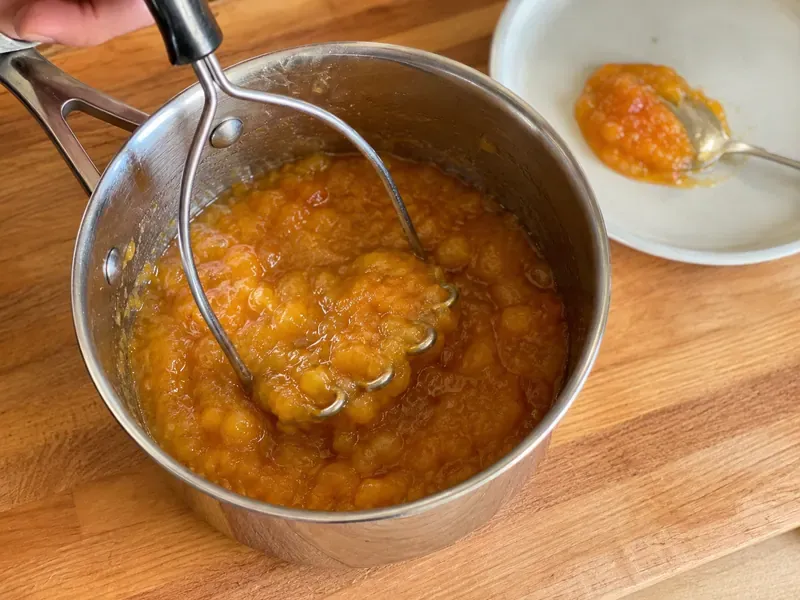 Thick peach jam mashed and tested on a spoon or chilled plate.