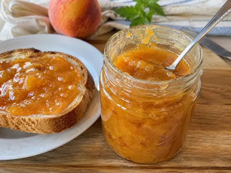 Finished small-batch peach jam served in a jar or spread on toast.