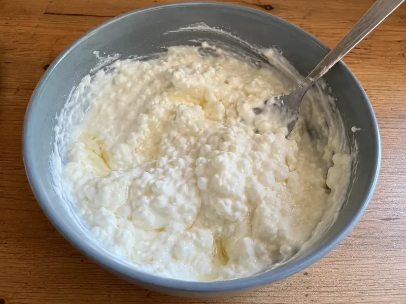 Cottage cheese, Greek yogurt, cream cheese, honey, vanilla, and lemon juice mixed in a bowl.