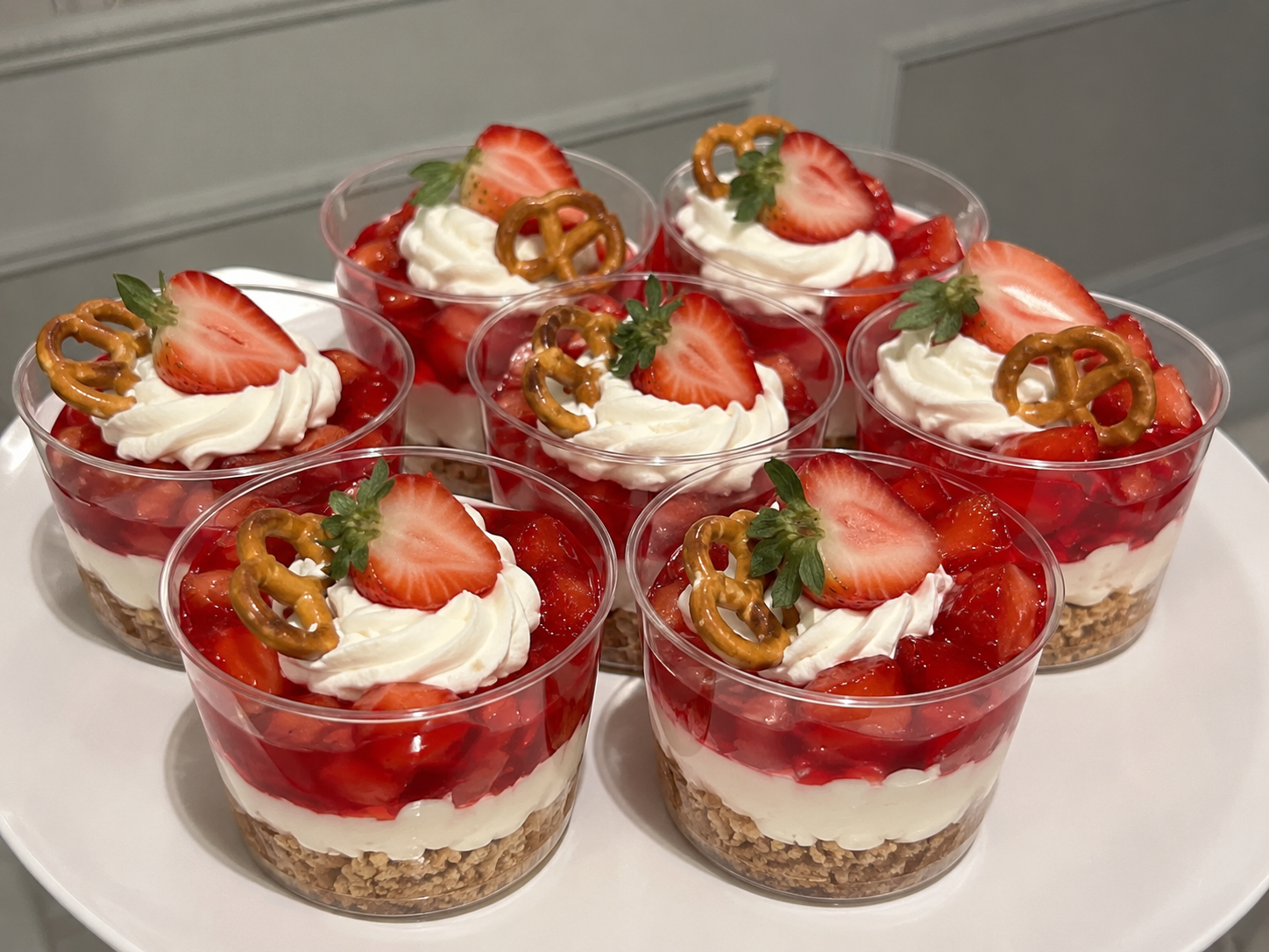Strawberry Pretzel Jello Salad Cups with pretzel crumbs, creamy filling, strawberry gelatin, and fresh strawberries.