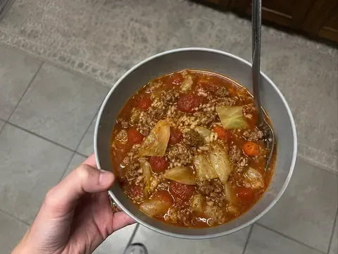 Stuffed cabbage roll soup with ground beef, cabbage, tomatoes, rice, carrots, herbs, and tomato broth.