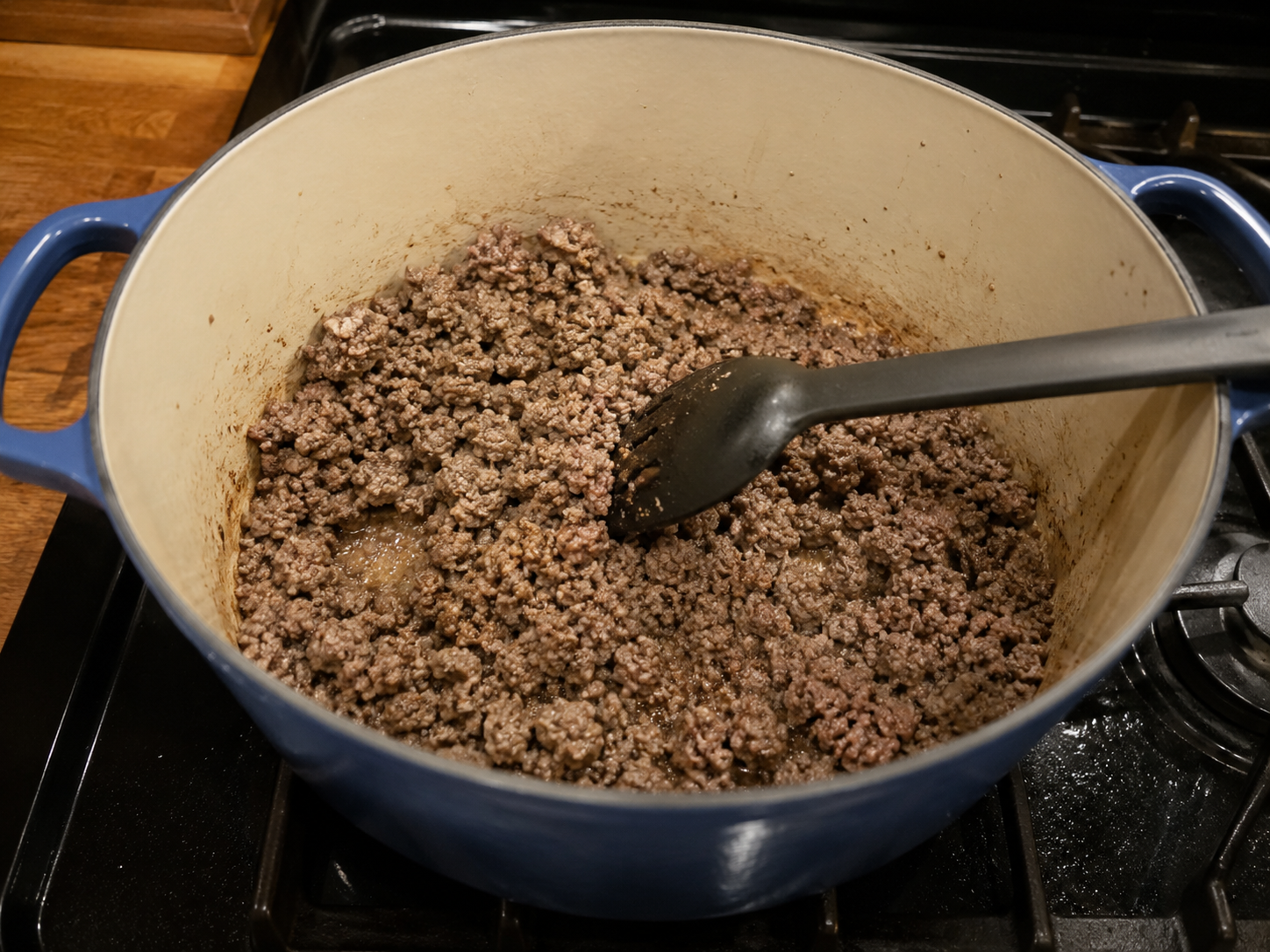 Ground beef browning in a large pot for stuffed cabbage roll soup.