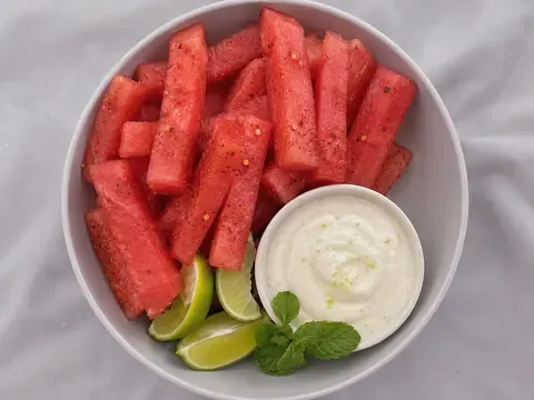 Tajín Watermelon Fries with Lime Yogurt Dip served with lime wedges and fresh mint.
