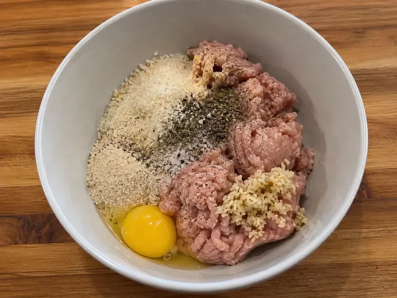 Ground turkey mixed with egg, parmesan, almond flour, garlic, and Italian seasoning for meatballs.