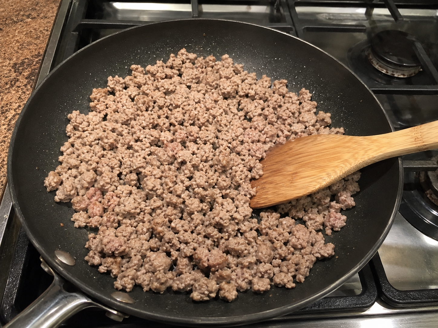 Lean ground turkey cooking in a skillet for turkey taco cauliflower rice bowls.