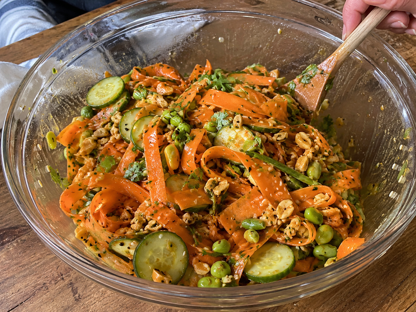 Carrot ribbon salad tossed with cucumber, green onions, peanuts, sesame seeds, edamame, and dressing.